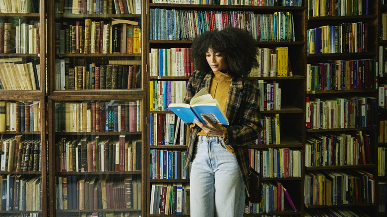 Wide shot of a woman reading in a bookstore