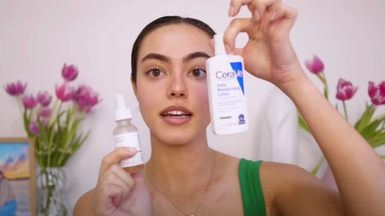 woman holding cerave moisturizing cream