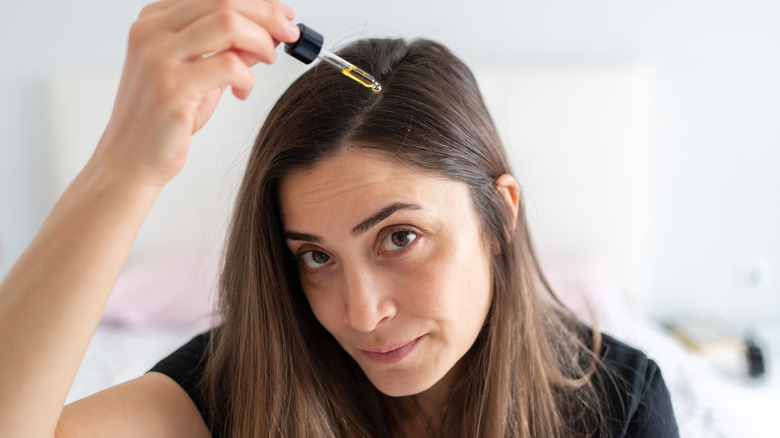 woman applying almond oil to scalp