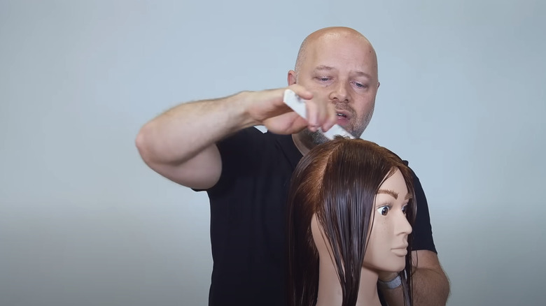 Man cutting hair on a mannequin head