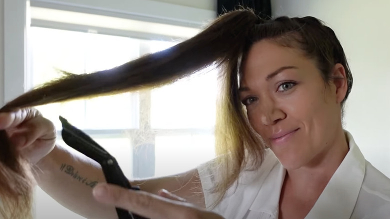 YouTube still of a woman cutting her own hair