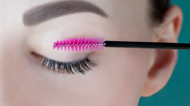 woman using spoolie on lashes