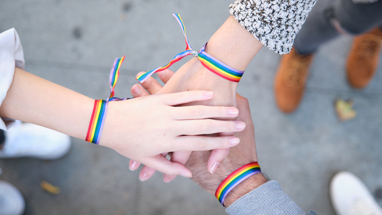 Hands with rainbow bracelets