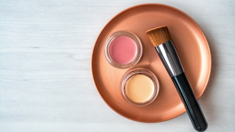 Blush, concealer, and brush on table