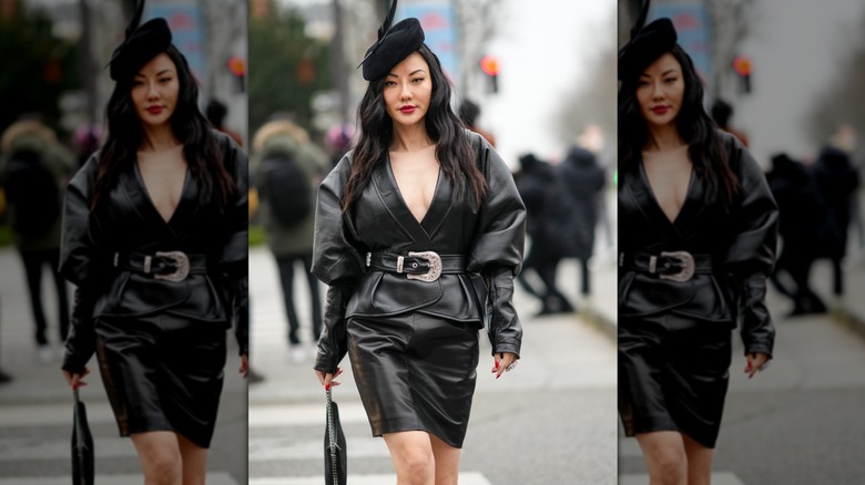 An influencer wearing black leather outfit with large western belt