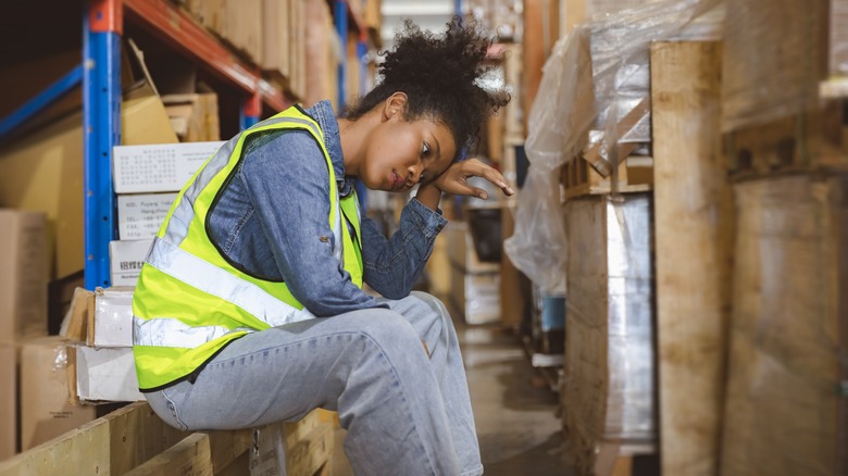 Exhausted warehouse employee sitting down