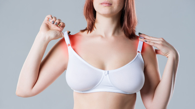 Woman raises tight bra straps