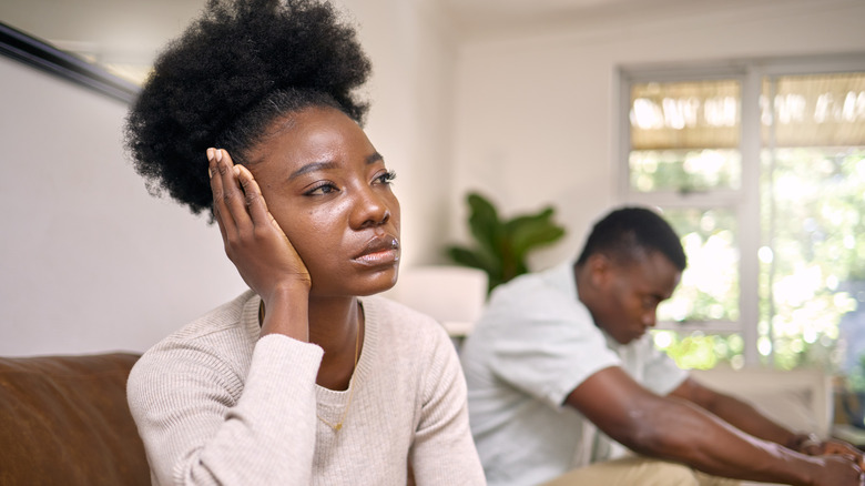 Upset woman and man sitting on couch