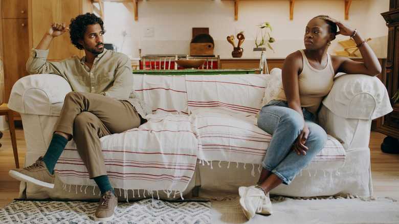 Couple leaning away from each other on the couch