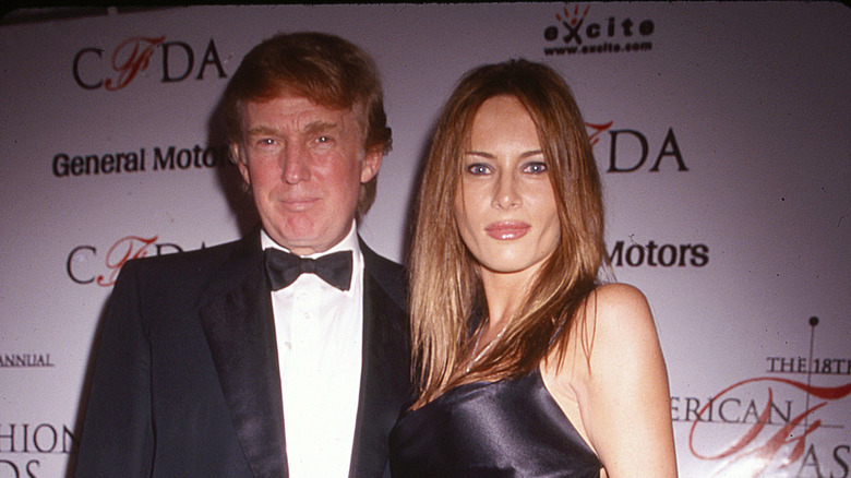 Donald Trump in a tuxedo and Melania Trump in a black sleeveless gown in 1999 at an event