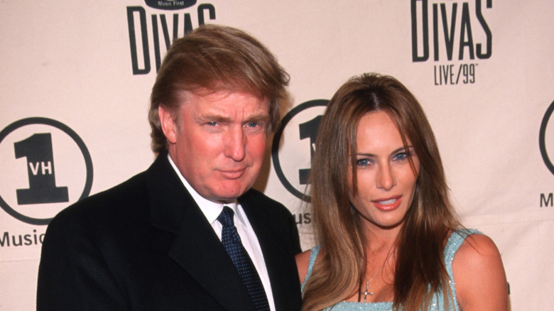 Donald Trump in a suit and Melania Trump in a blue dress at an event