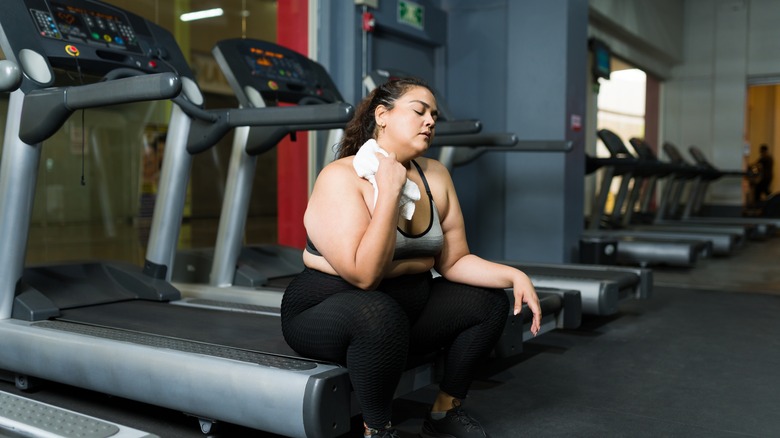 Woman sitting on treadmill post-workout