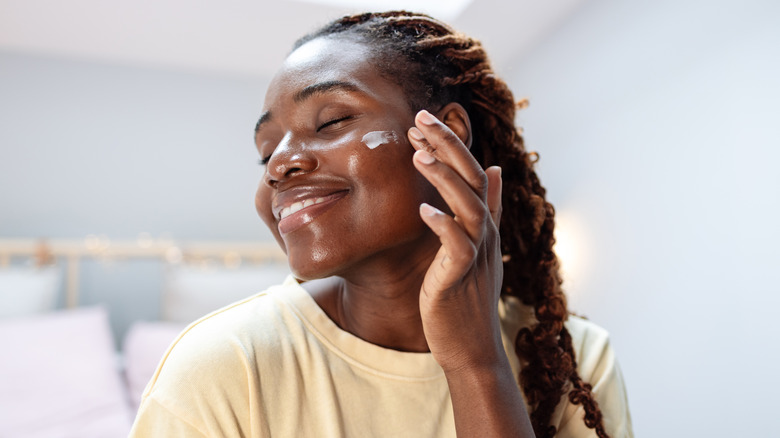 Woman applying moisturizer