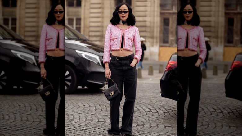 A woman in black jeans and pink jacket 
