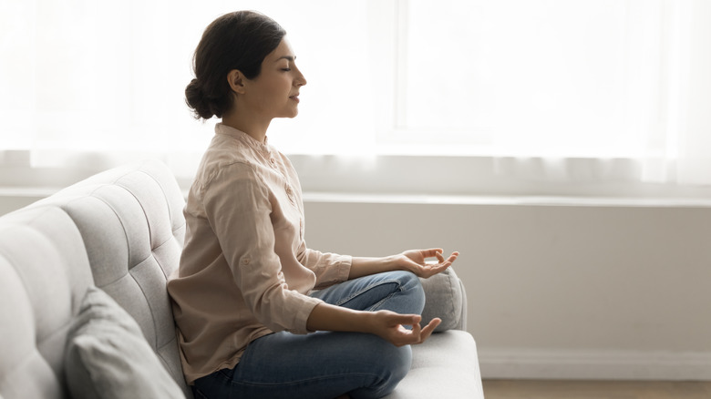 A woman closing her eyes and meditating