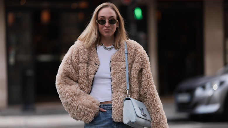 Woman wearing faux fur jacket with jeans