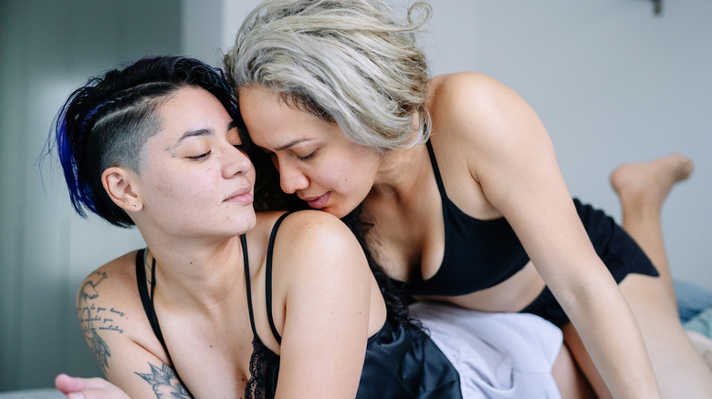 two women in bed engaging in sexy times