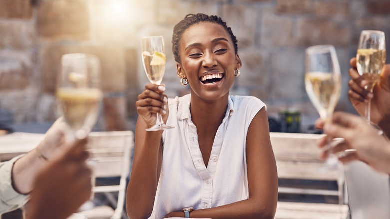 Woman smiling while holding champagne glass