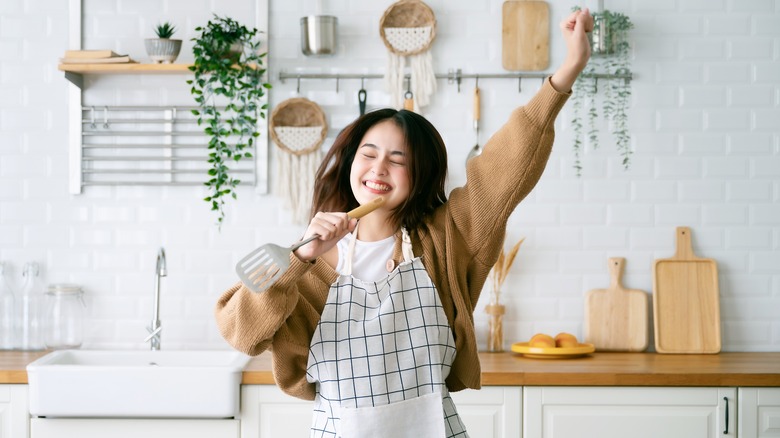 Happy woman dancing in kitchen