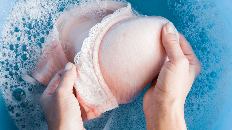 A person washing a bra