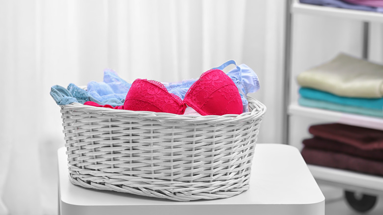 A stack of bras inside a laundry basket