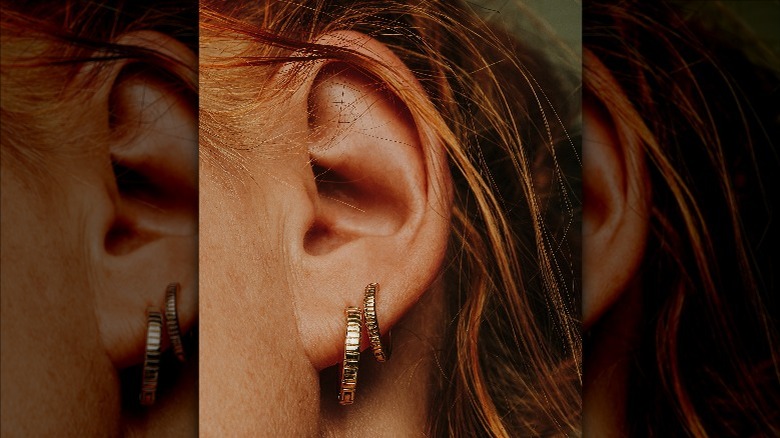 Ear with gold hoop earrings