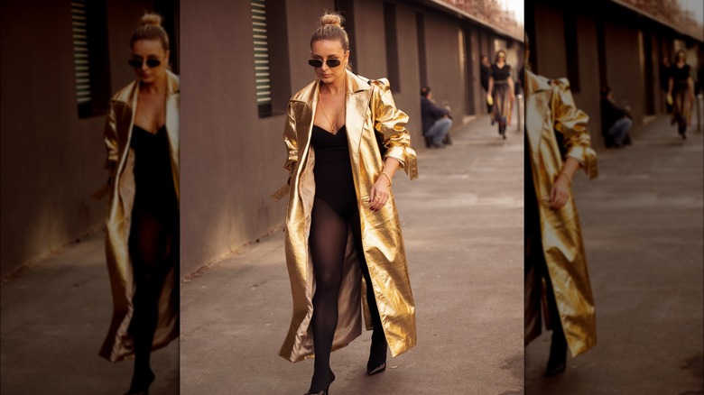 A woman in a gold leather trench coat 