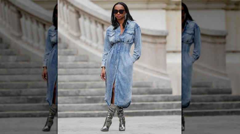 A woman wearing metallic boots and a blue denim dress