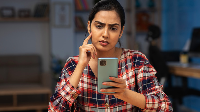 Woman looking worried at her phone