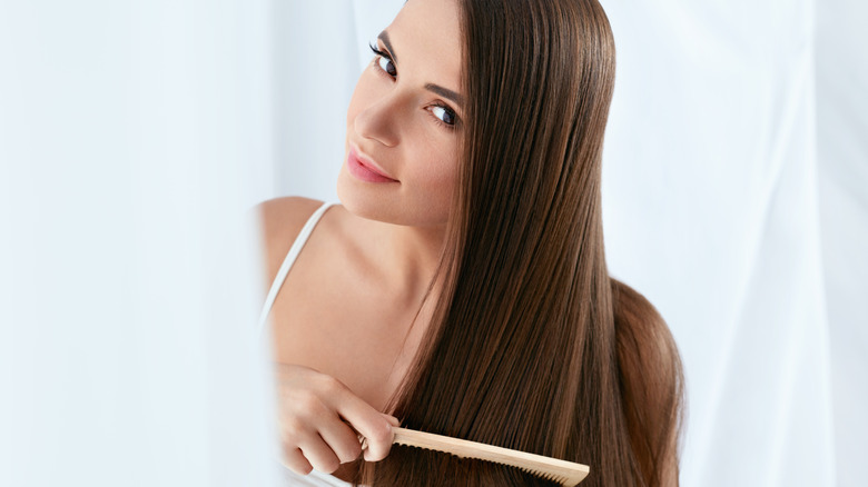 woman combing through long hair