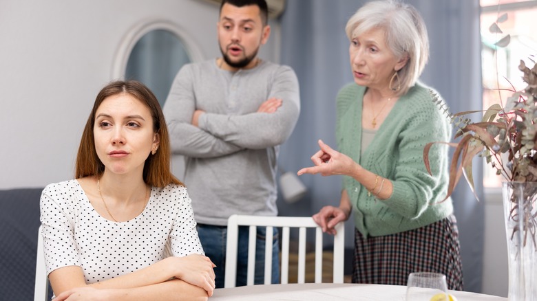Woman looks away from family members who are visually upset with her