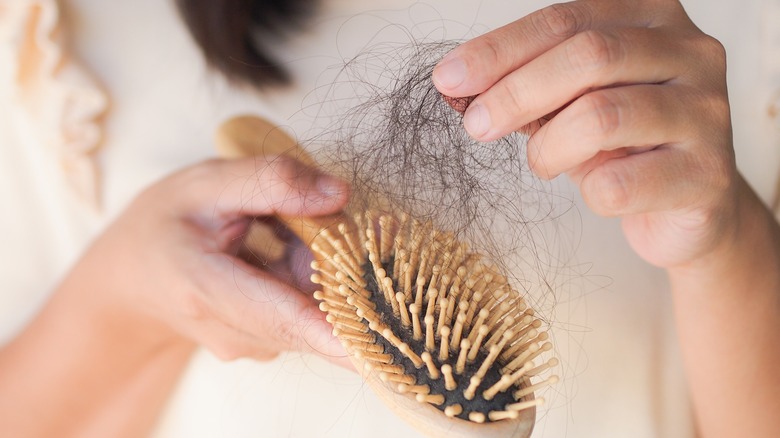 Woman picking hairs from brush