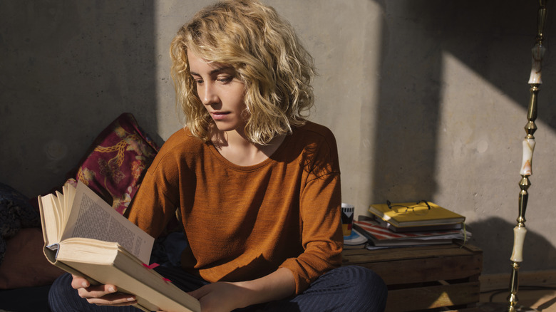 Woman reading in shadowy room