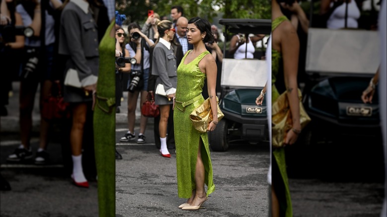 woman posing on the street wearing a green dress