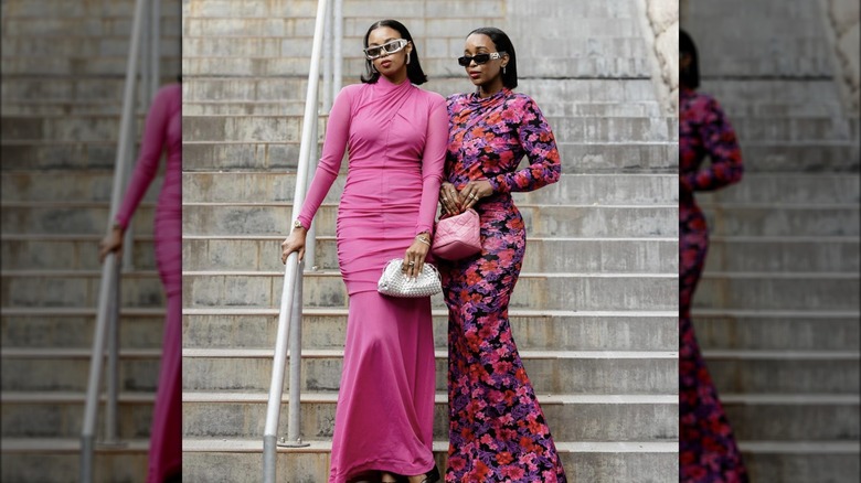 Two women wearing pink and floral dresses