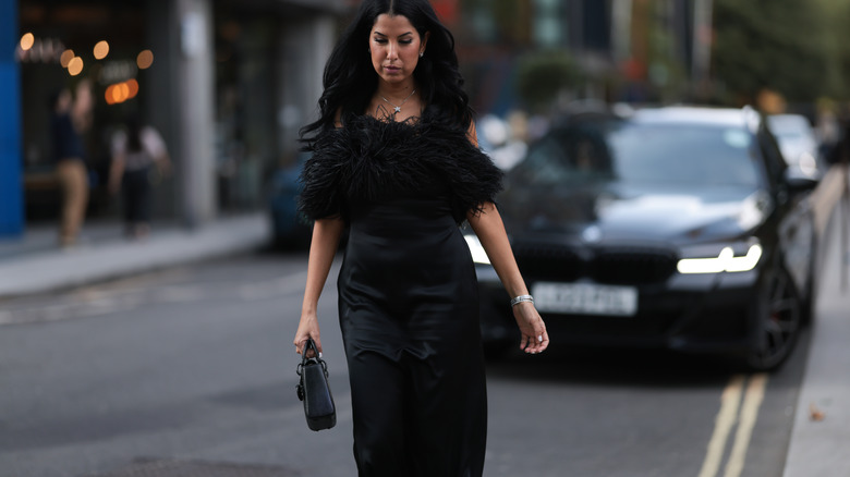 woman walking down the street in a black dress