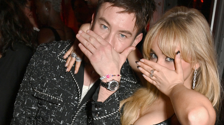 Barry Keoghan and Sabrina Carpenter posing with hands covering mouth