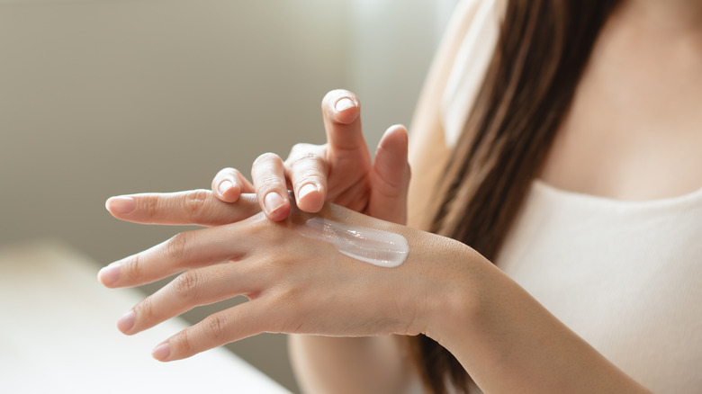 Close up of a woman applying moisturizer to her hand