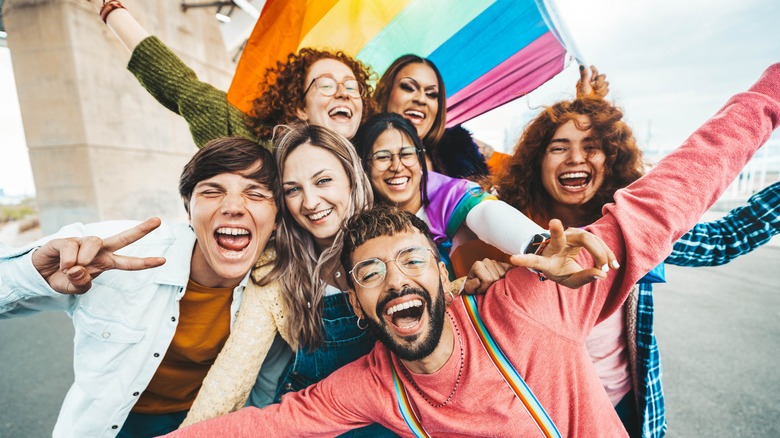 A group of young people in front of the Pride flag 