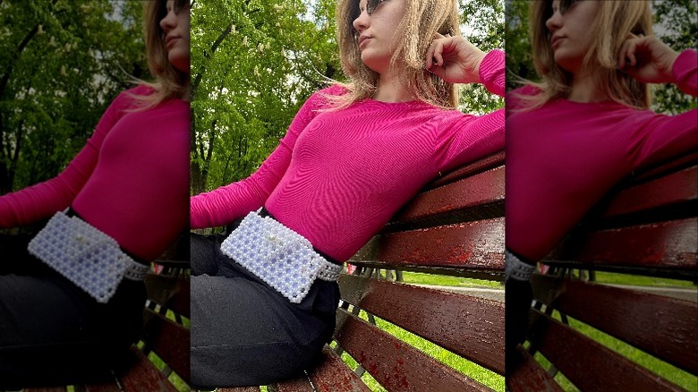 Woman on bench with pink shirt and belt bag