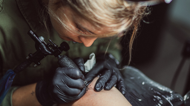 Woman giving tattoo