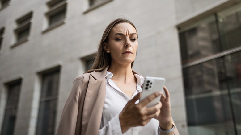 Woman looking skeptical on her phone 