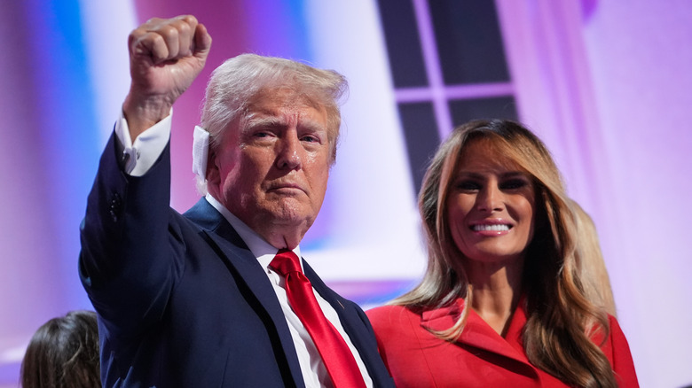 Donald Trump in a blue suit and Melania Trump in a red blazer at an event