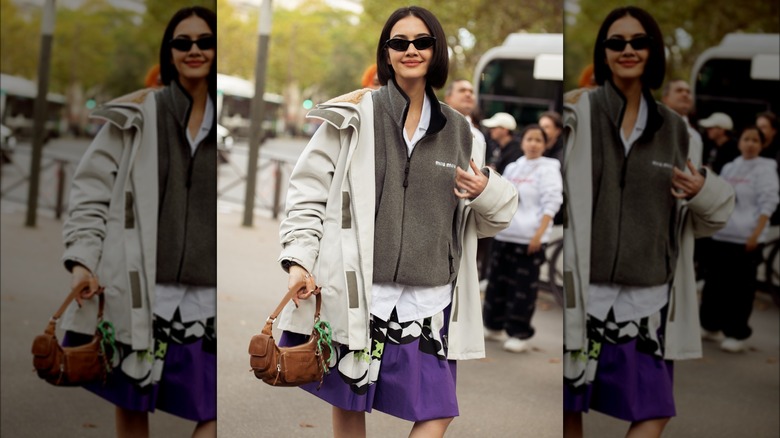 A woman wearing a jacket and skirt