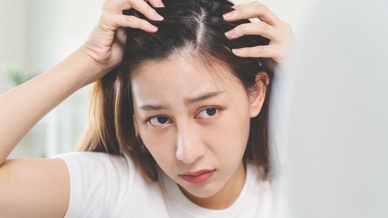 Woman examining scalp