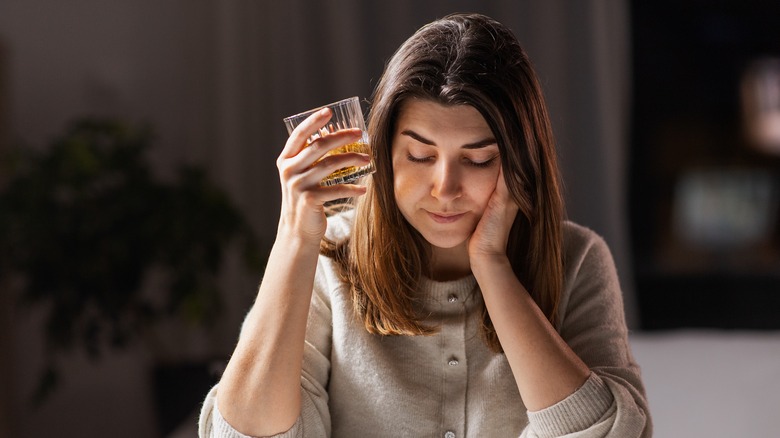 unhappy woman with glass of alcohol 