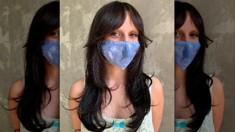 woman with long dark hair and blue mask
