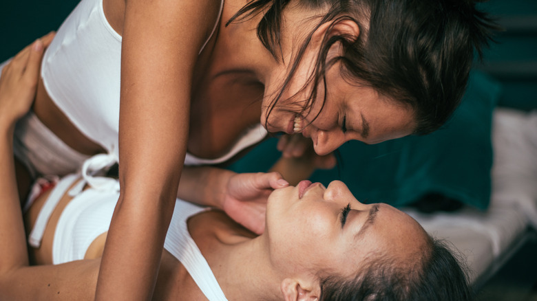 Two women being intimate in bed