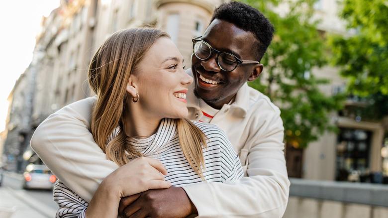 Couple smiling and embracing outside