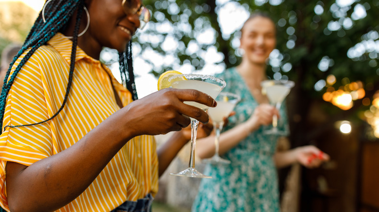 Women outside holding cocktails